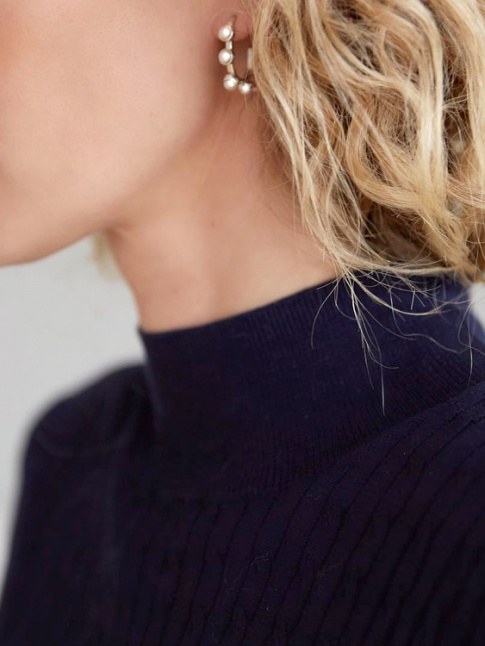 Cheveux boucls blonds + pull fin bleu marine + boucles d'oreilles chics = le bon mix