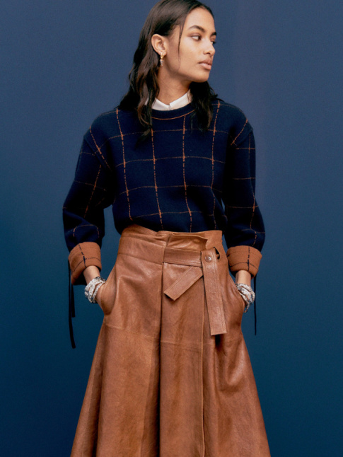 Jupe portefeuille en cuir + pull bleu marine  carreaux = le bon mix