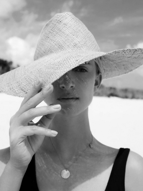 Mlant chapeau de paille, mdaille et maillot de bain une pice noir, ce look de plage a tout bon !