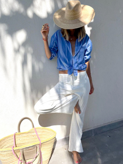 Mlant large chapeau de paille, pantalon blanc et chemise masculine noue sur le devant, ce look a tout bon !