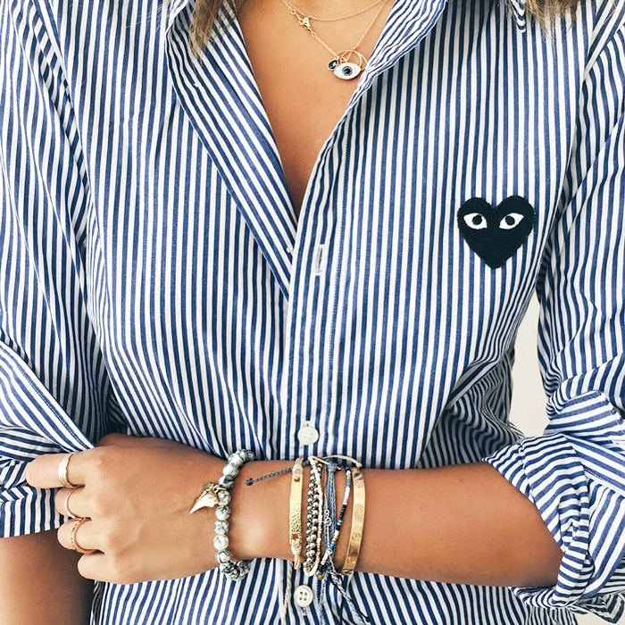 Port�e roulott�e et associ�e � une poign�e de fins bracelets, la chemise ray�e a tout pour plaire !