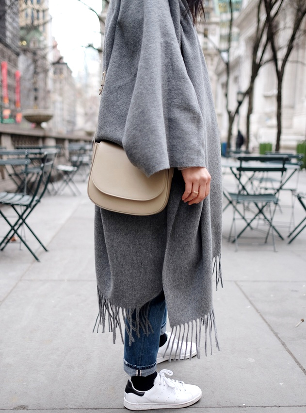 Port� avec une paire de baskets blanches, le maxi poncho gris devient plus urbain que folk
