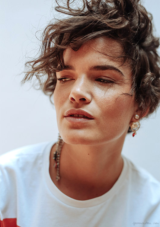 Tee-shirt blanc + coupe courte boucl�e + boucles d'oreilles audacieusement fantaisies = le bon mix