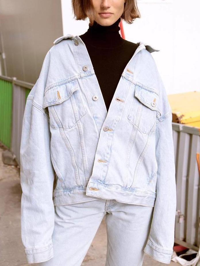 Accompagn�e d'un sous-pull noir et port�e bascul�e en arri�re, la veste en jean oversize gagne en caract�re