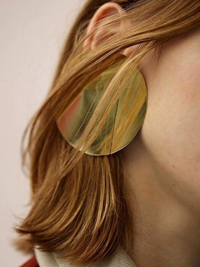 Oui aux maxi boucles d'oreilles patin�es par quelques m�ches de cheveux !