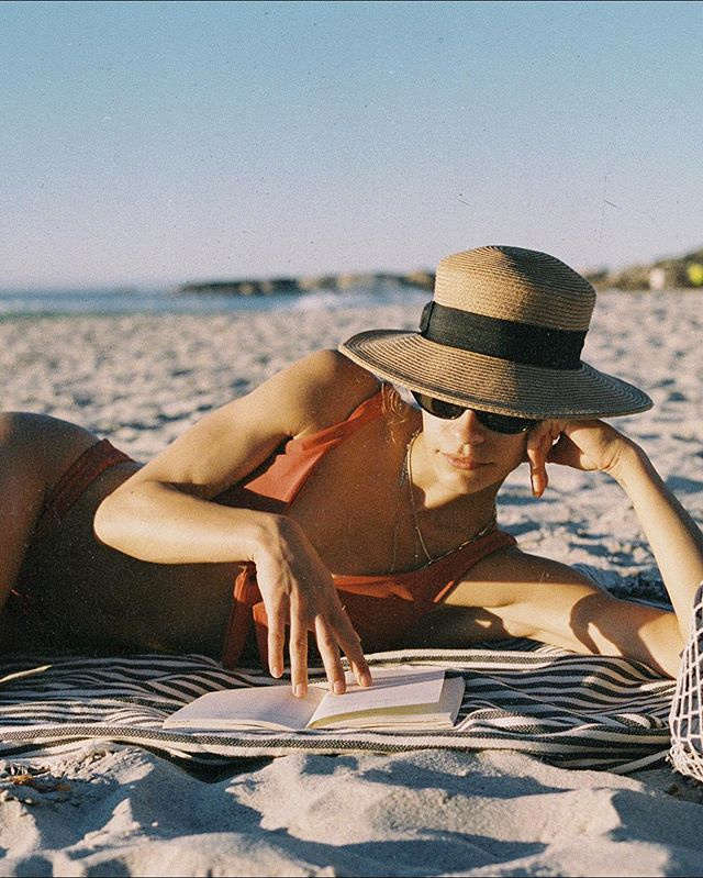 Chapeau en paille + serviette � rayures + bikini + roman passionnant = le bon mix