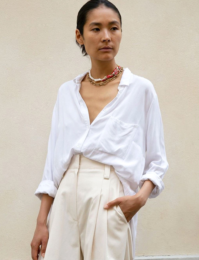 Chemise blanche l�g�rement bascul�e vers l'arri�re + pantalon � pinces + duo de colliers ras du cou = le bon mix