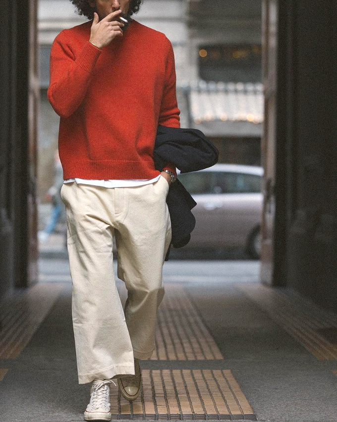 Pantalon large beige court sur la cheville + tee-shirt blanc d�passant d'un pull rouge col rond = le bon mix