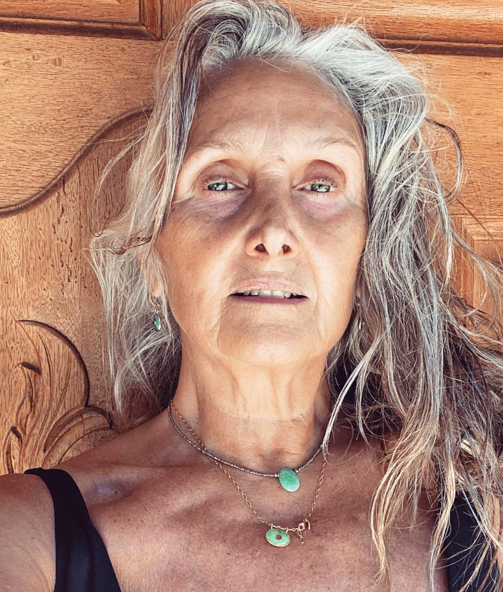 Cheveux décoiffés par l'eau salée + fins colliers + maillot de bain noir = le bon mix