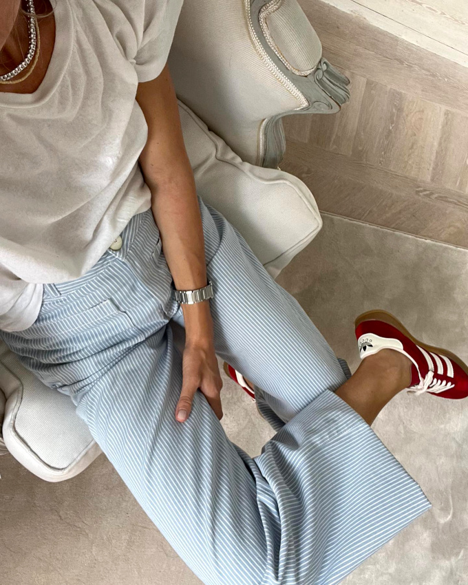 Port� avec une paire de baskets bordeaux, le pantalon ray� bleu et blanc se fait plus automnal qu'estival