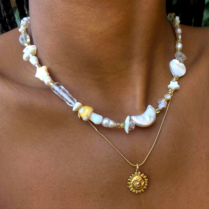 Collier nacr� + pendentif dor� + peau bronz�e = le bon mix