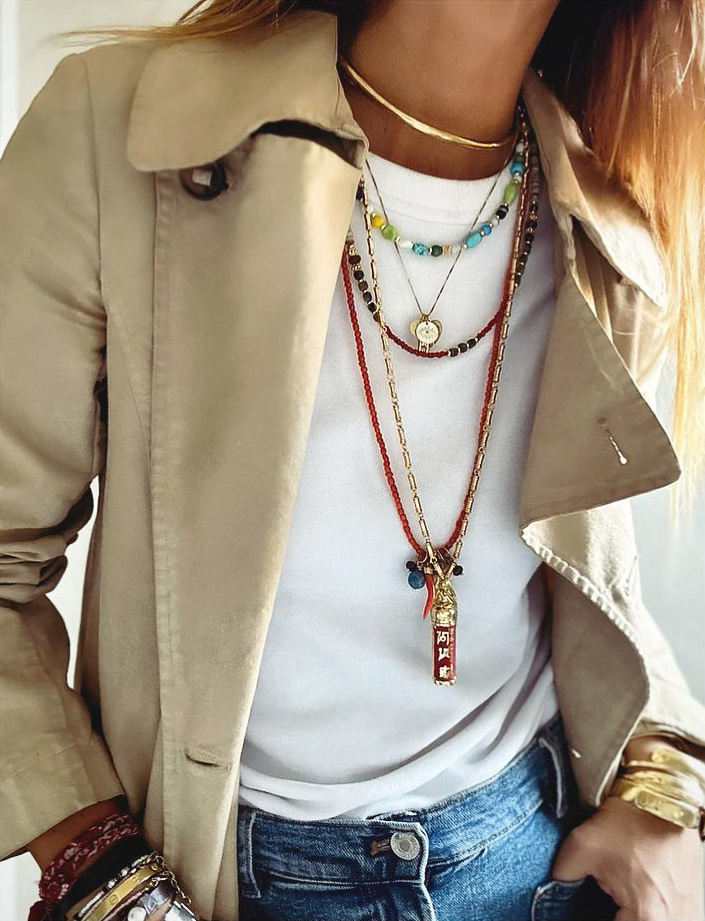 Rien de tel que l'accumulation de bijoux pour donner du relief au duo trench/tee-shirt blanc !