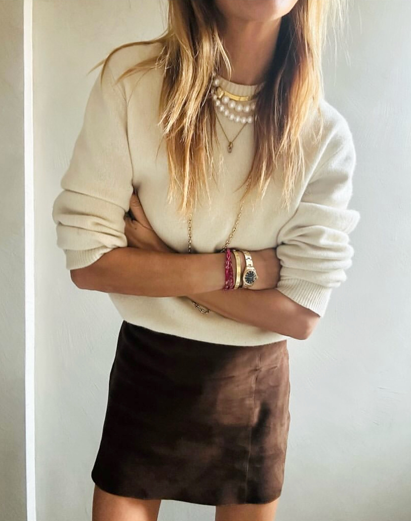 Mini jupe en daim marron + gros pull blanc cass + accumulation de bijoux = le bon mix