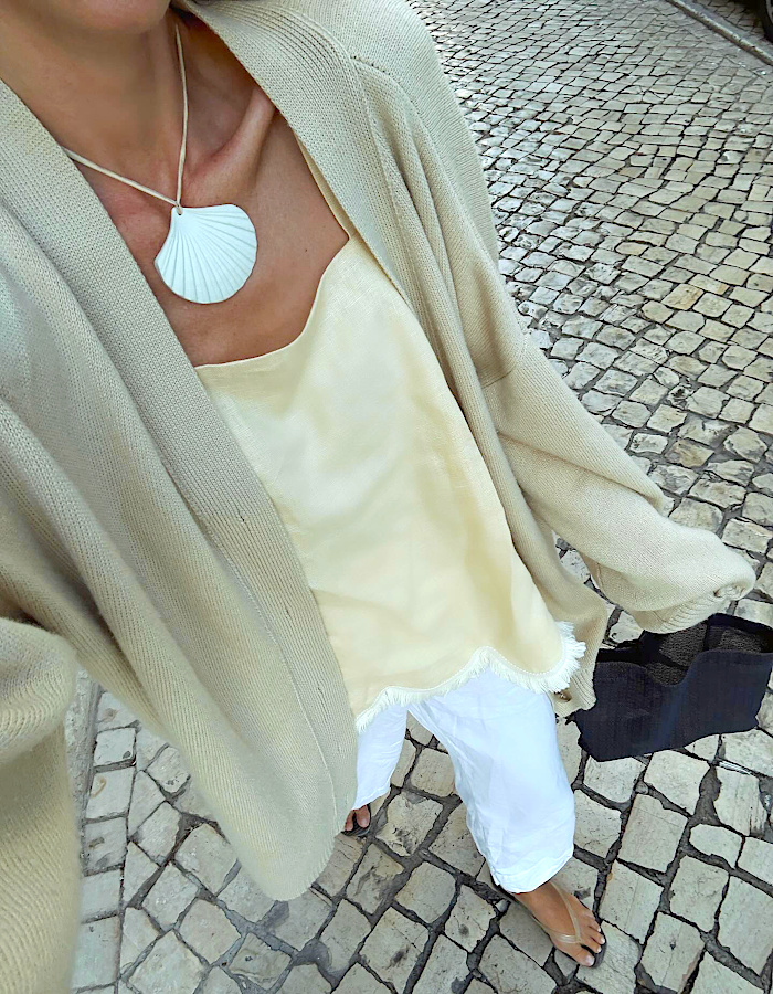 Collier coquillage oversize sur top satiné crème et gilet beige