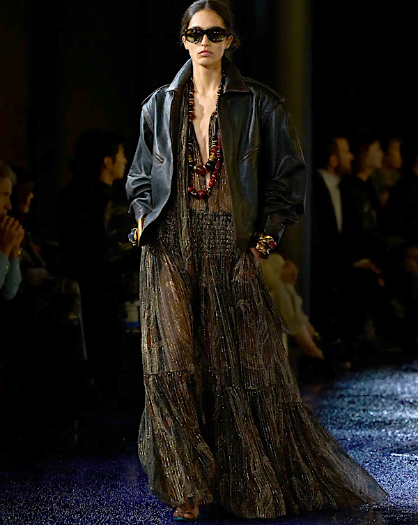Robe longue transparente et veste en cuir noire portées avec des bijoux imposants