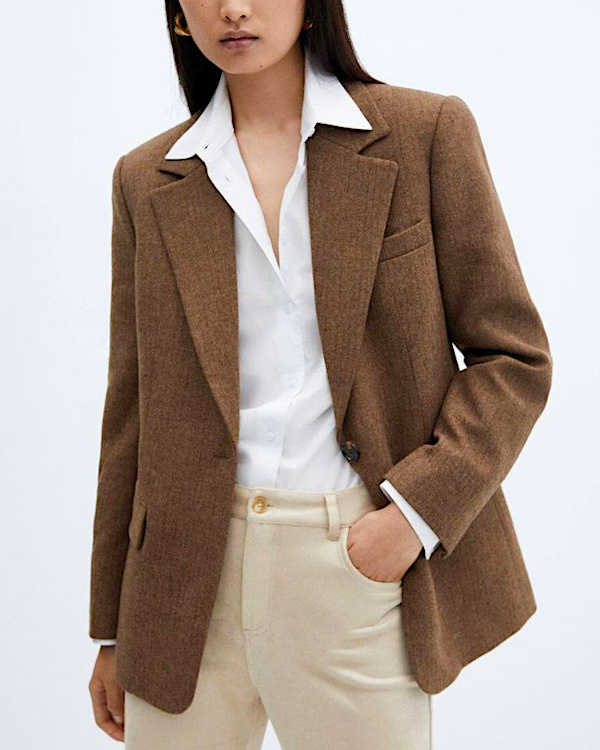 Femme portant un blazer marron avec une chemise blanche et un pantalon écru