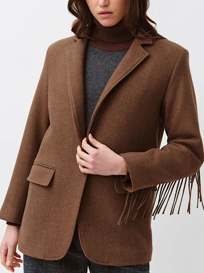 Femme portant un blazer marron à franges sur un col roulé