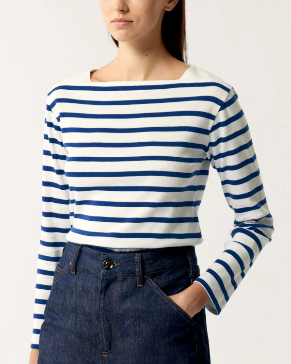 Marinière blanche à rayures bleues portée avec un jean brut taille haute